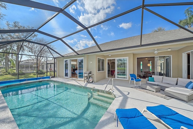 view of swimming pool featuring area for grilling, outdoor lounge area, ceiling fan, a patio, and a lanai