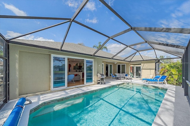 view of swimming pool with a patio area, area for grilling, and a lanai