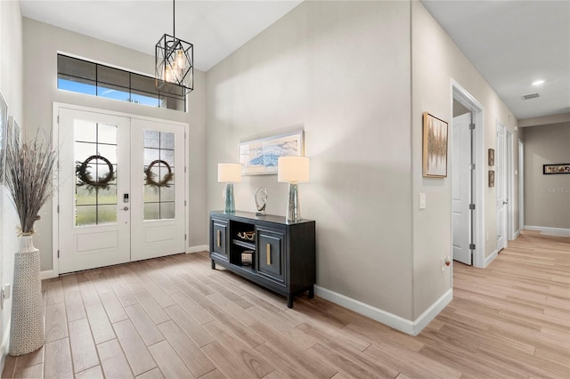 entryway with plenty of natural light, light hardwood / wood-style floors, and french doors