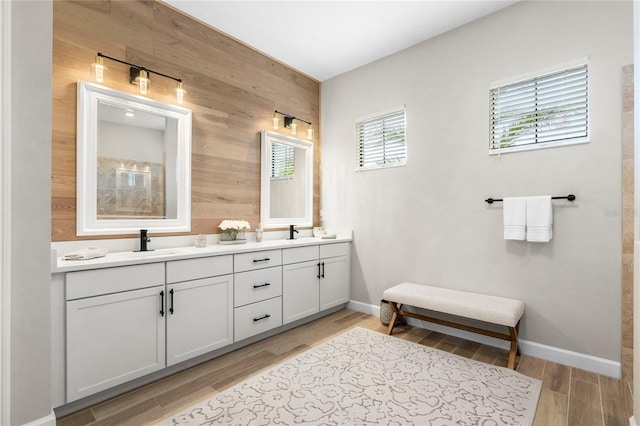 bathroom with hardwood / wood-style flooring, vanity, and wood walls