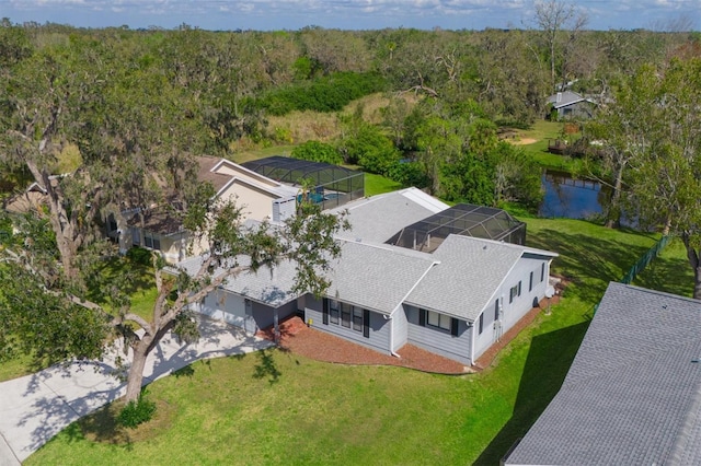 drone / aerial view featuring a view of trees and a water view