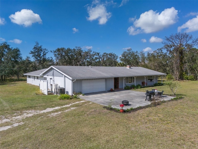 single story home with an attached garage, driveway, central AC unit, and a front lawn