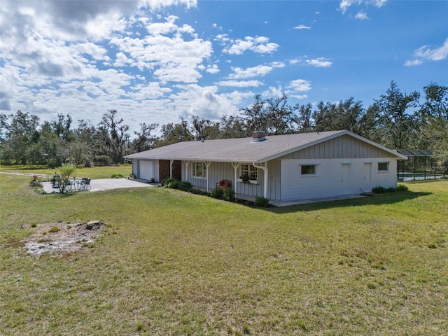 single story home featuring a garage, a front yard, concrete driveway, and board and batten siding