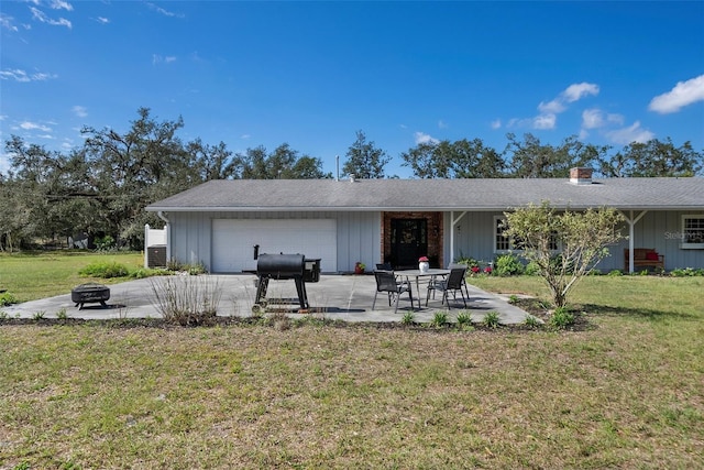 back of property featuring an outdoor fire pit, a lawn, a patio area, and board and batten siding