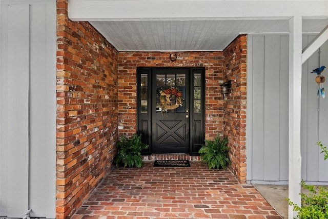 view of exterior entry with brick siding