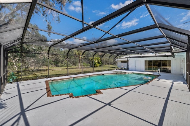 pool with glass enclosure, a patio, and a hot tub