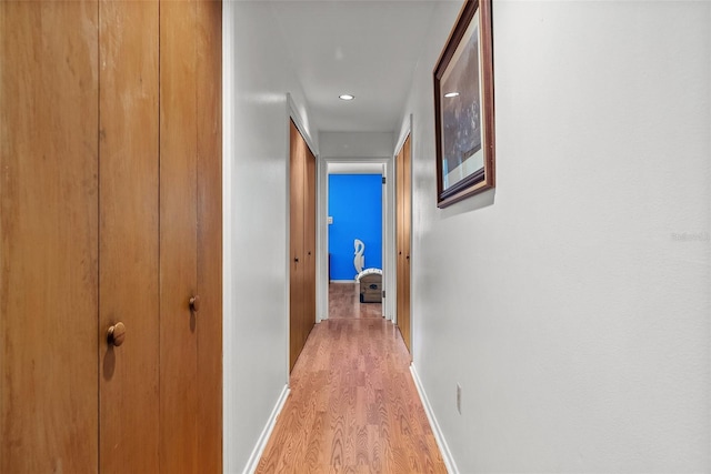 corridor featuring light wood-style floors and baseboards