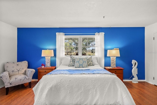 bedroom featuring baseboards and wood finished floors