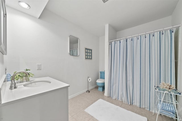 bathroom with toilet, tile patterned floors, baseboards, and vanity