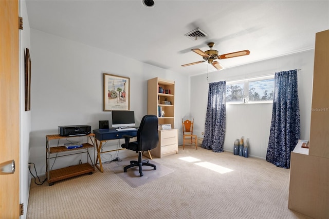 office space featuring visible vents, a ceiling fan, and light colored carpet