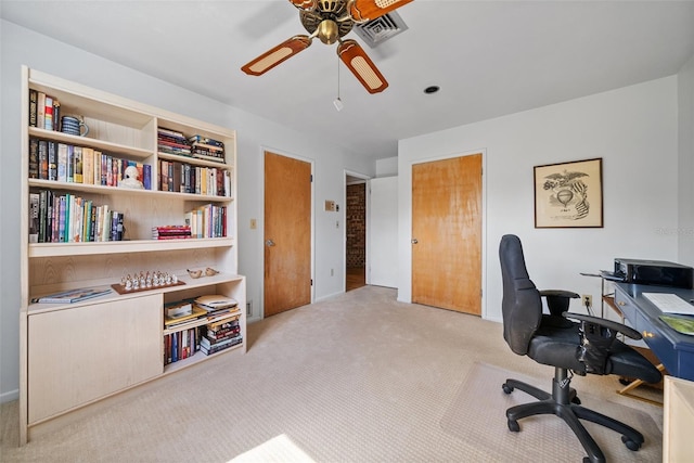 office featuring light colored carpet, ceiling fan, and visible vents