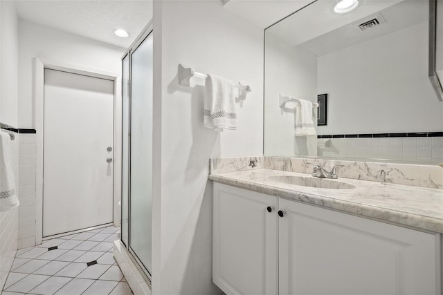 bathroom with tile patterned flooring, recessed lighting, visible vents, vanity, and a stall shower