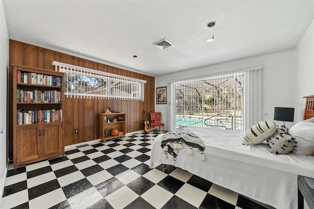 bedroom featuring access to exterior, visible vents, wooden walls, and tile patterned floors