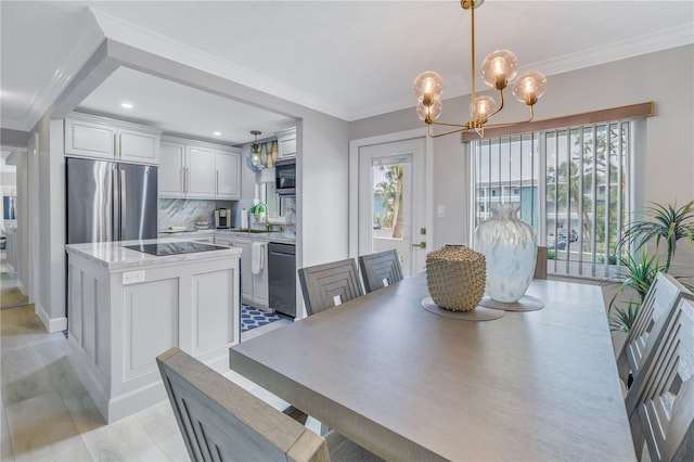 dining area with ornamental molding, plenty of natural light, and an inviting chandelier