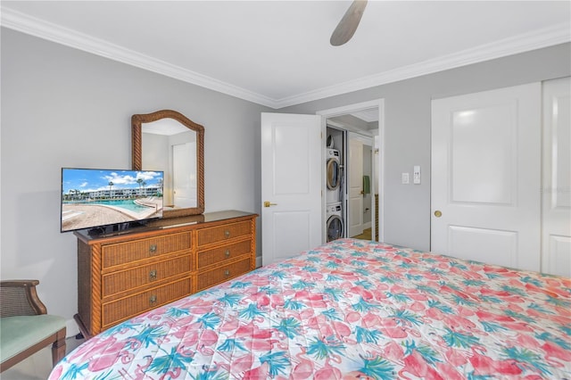 bedroom with a ceiling fan, crown molding, and stacked washer and clothes dryer