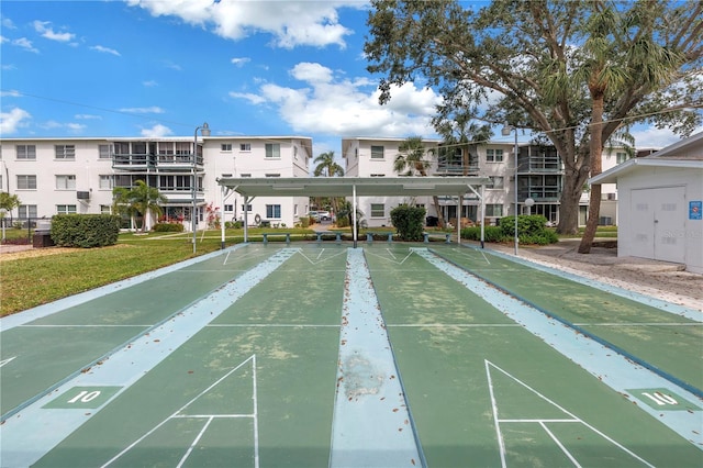 view of community featuring shuffleboard and a lawn