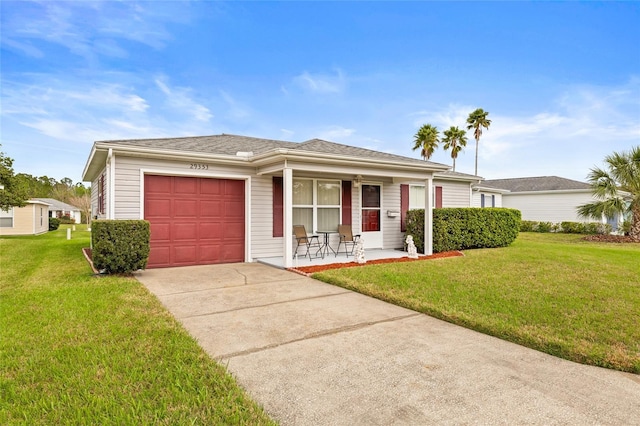 ranch-style home with a porch, an attached garage, a shingled roof, driveway, and a front lawn