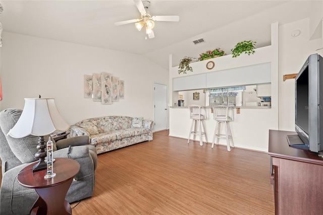 living room with lofted ceiling, visible vents, ceiling fan, and wood finished floors