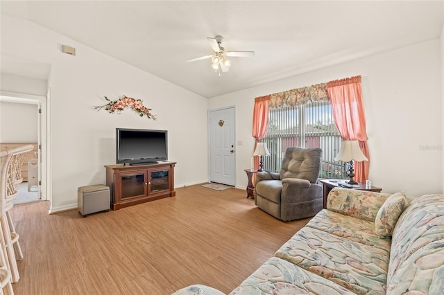 living area with light wood-type flooring, ceiling fan, baseboards, and lofted ceiling