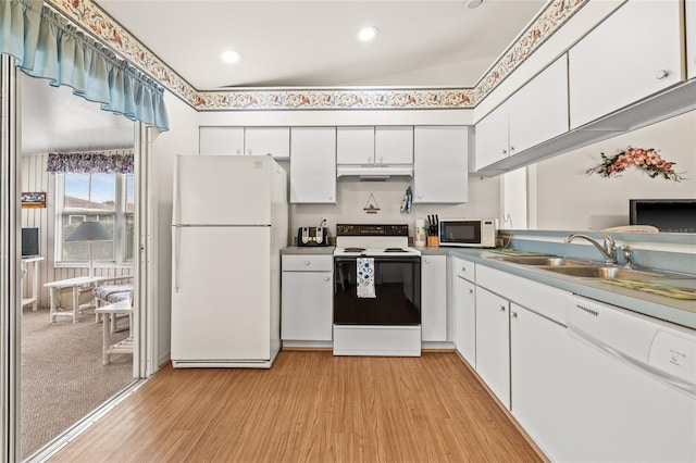 kitchen with white appliances, light wood-type flooring, under cabinet range hood, white cabinetry, and a sink