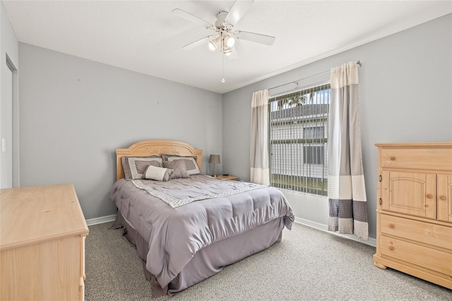 carpeted bedroom with a ceiling fan and baseboards