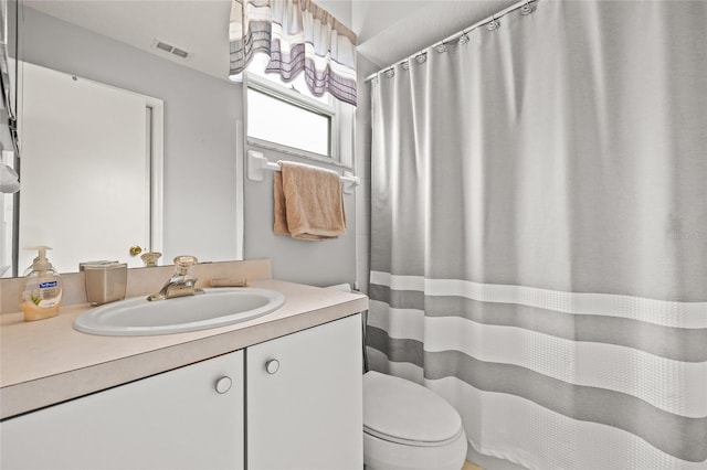 full bathroom with toilet, visible vents, and vanity