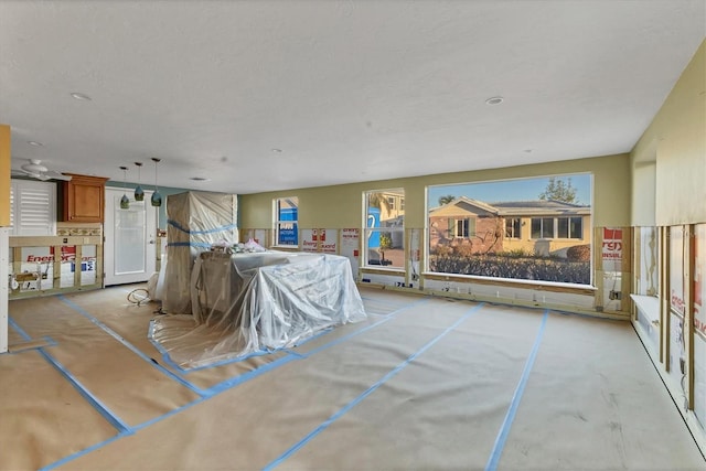 interior space with concrete flooring, hanging light fixtures, and brown cabinets