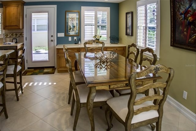 dining room featuring light tile patterned floors, baseboards, and a wealth of natural light