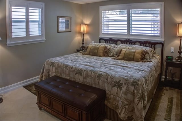 bedroom with tile patterned flooring, multiple windows, and baseboards