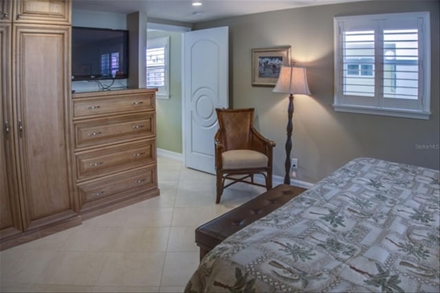 bedroom featuring light tile patterned floors, multiple windows, baseboards, and recessed lighting