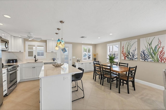 6140 Midnight Pass Rd Unit A10, Sarasota, FL 34242 - kitchen with stainless steel appliances, a center island, white cabinetry, recessed lighting, and a breakfast bar