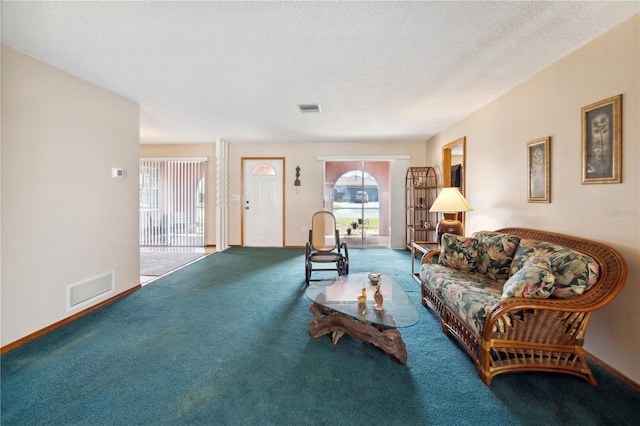 carpeted living room featuring a textured ceiling, visible vents, and baseboards