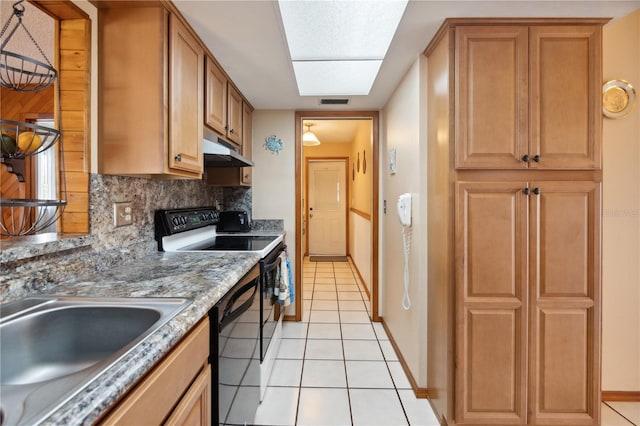 kitchen featuring light tile patterned floors, under cabinet range hood, a sink, electric stove, and backsplash