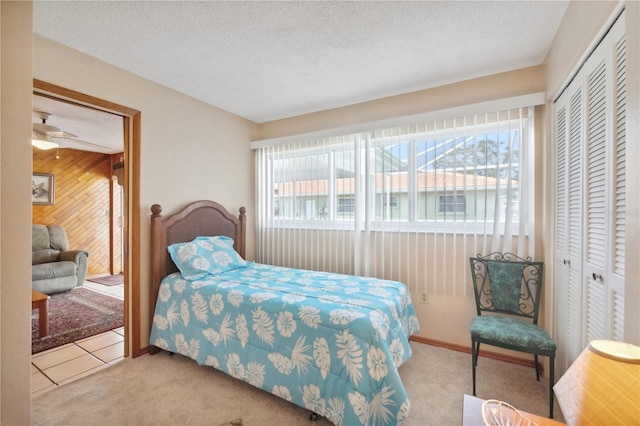 bedroom featuring a textured ceiling, multiple windows, a closet, and light colored carpet