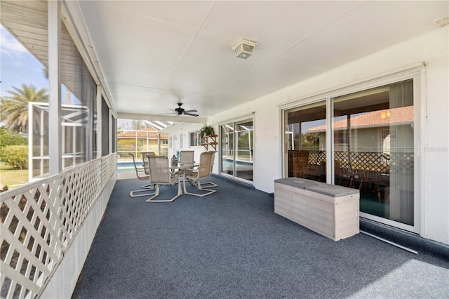 unfurnished sunroom featuring ceiling fan