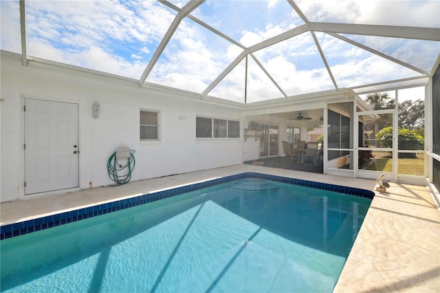 outdoor pool with ceiling fan, a patio area, and a lanai