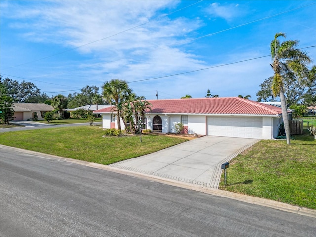 ranch-style house with driveway, a garage, a front yard, and a tiled roof