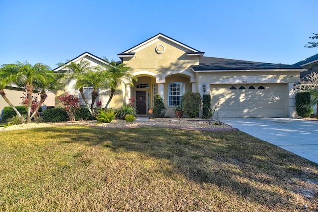 view of front of house with a garage, concrete driveway, a front yard, and stucco siding