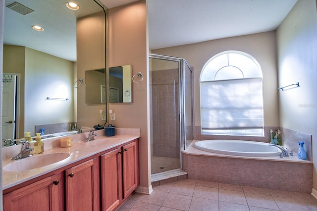 bathroom with a stall shower, visible vents, a sink, and tile patterned floors