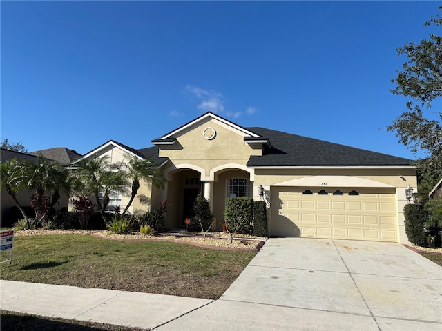 ranch-style house with an attached garage, a shingled roof, driveway, stucco siding, and a front yard