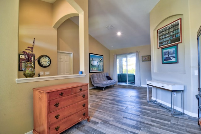 sitting room with dark wood-type flooring, lofted ceiling, and baseboards