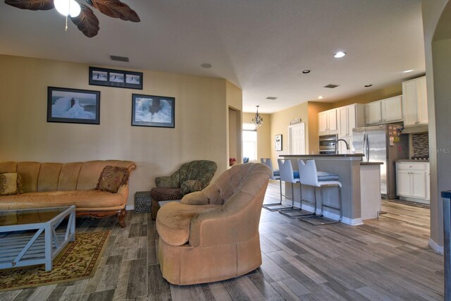 living area featuring baseboards, visible vents, ceiling fan, wood finished floors, and recessed lighting