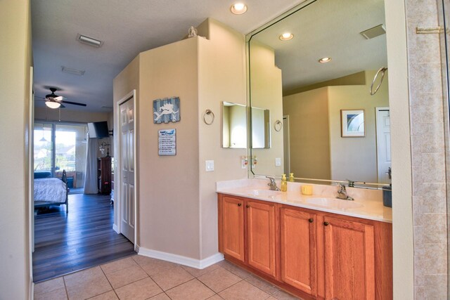 full bathroom featuring double vanity, ensuite bath, a sink, and tile patterned floors