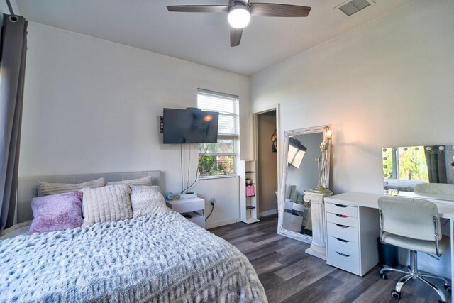 bedroom with a ceiling fan, dark wood-style flooring, visible vents, and baseboards