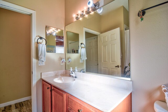 full bathroom featuring vanity and baseboards