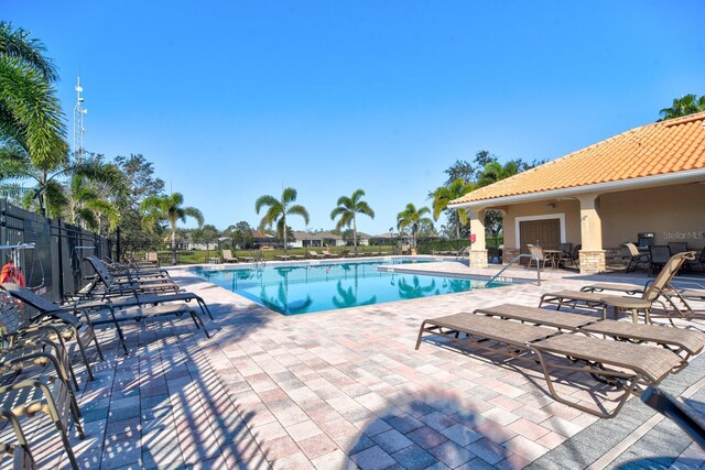 community pool featuring a patio and fence