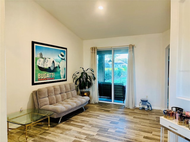 living area with lofted ceiling, light wood-style floors, and baseboards