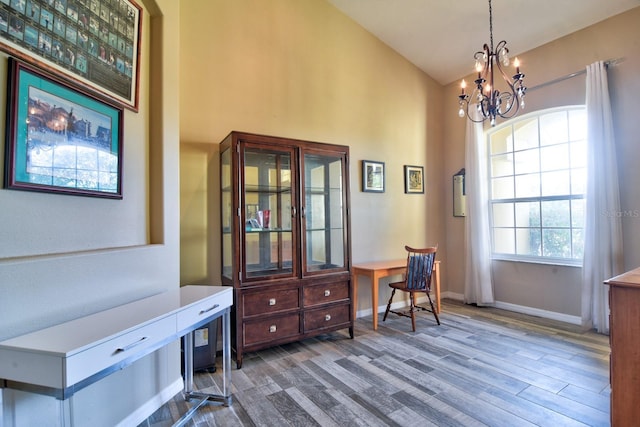 home office with lofted ceiling, a notable chandelier, baseboards, and wood finished floors