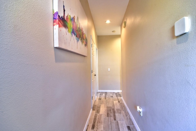 corridor with recessed lighting, wood finished floors, and baseboards