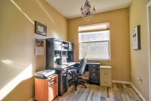 office with an inviting chandelier, light wood-style flooring, and baseboards